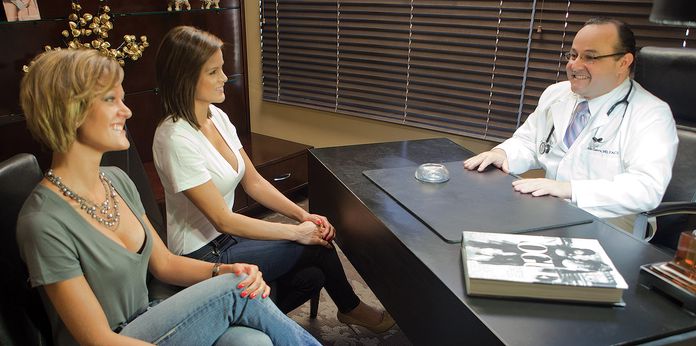 Dr. Aldo Guerra talking with patient in office